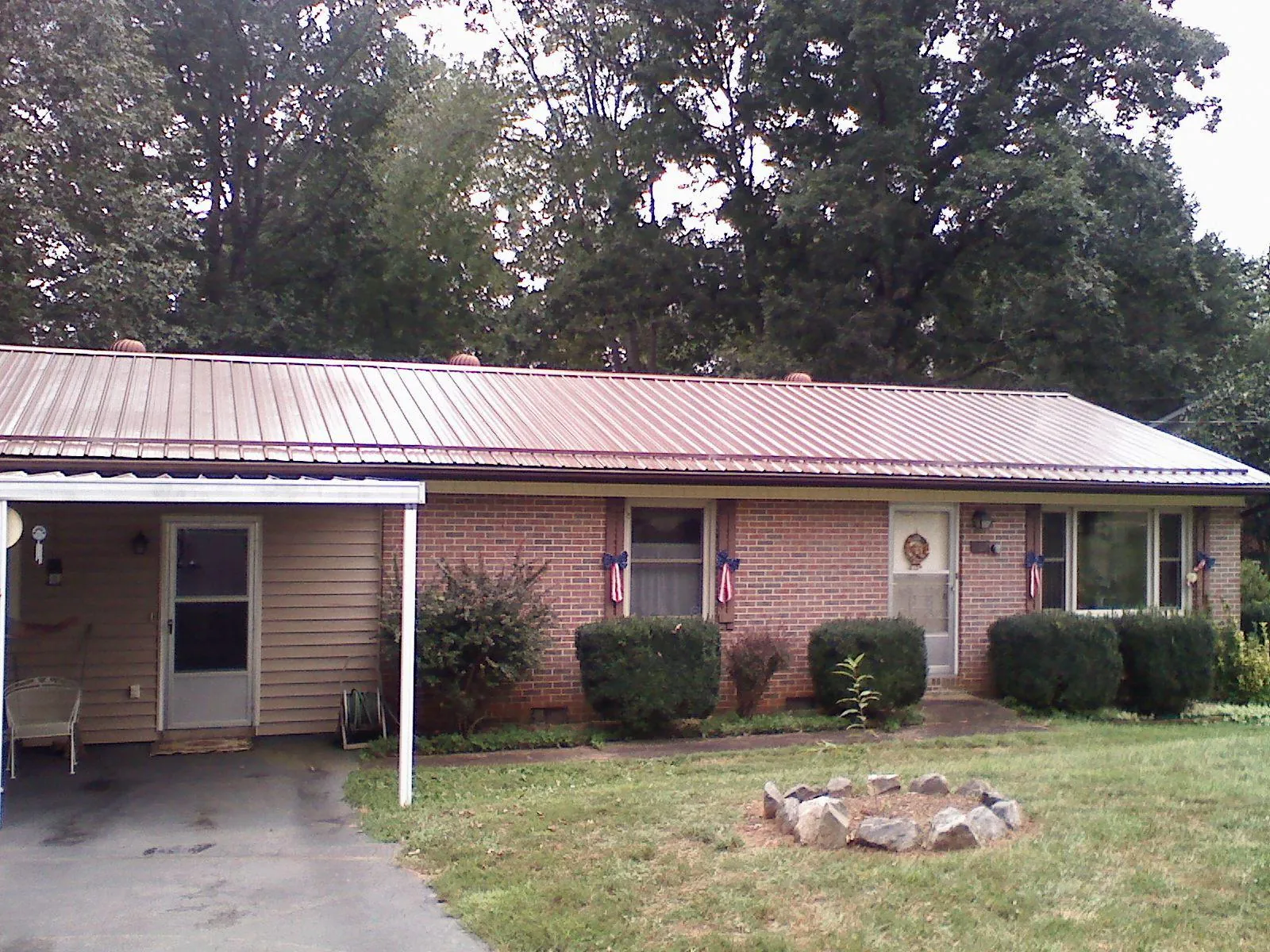 Bronze metal roof and carport on a brick ranch home — Roof Repair work by our crew in Hempstead